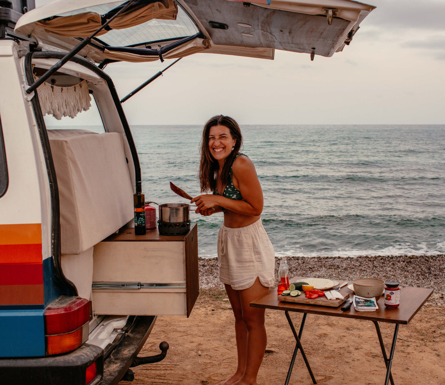 Angie kocht in ihrem alten Bulli am Meer.