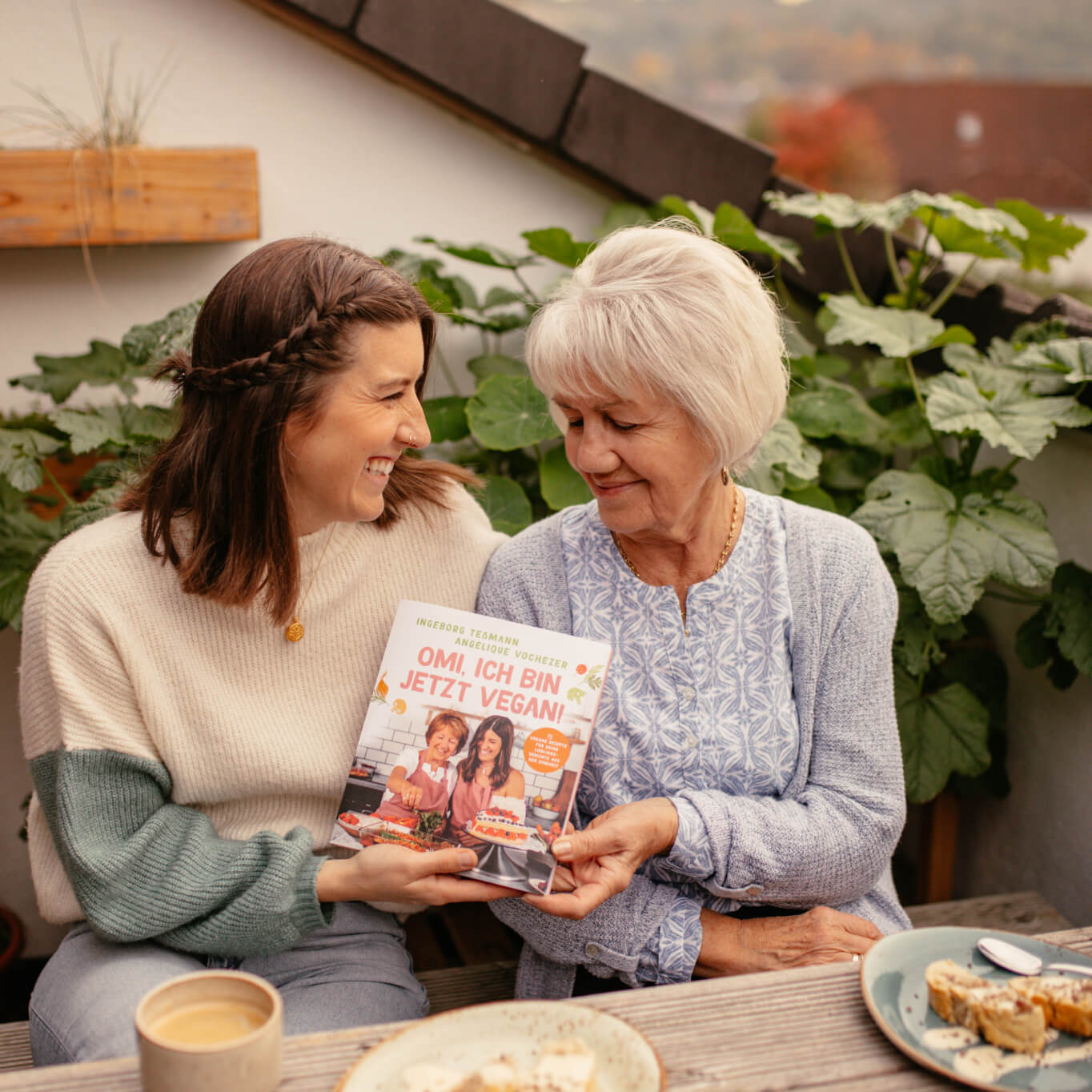 Angie und Omi auf der Terrasse mit ihrem Kochbuch "Omi, ich bin jetzt vegan!"